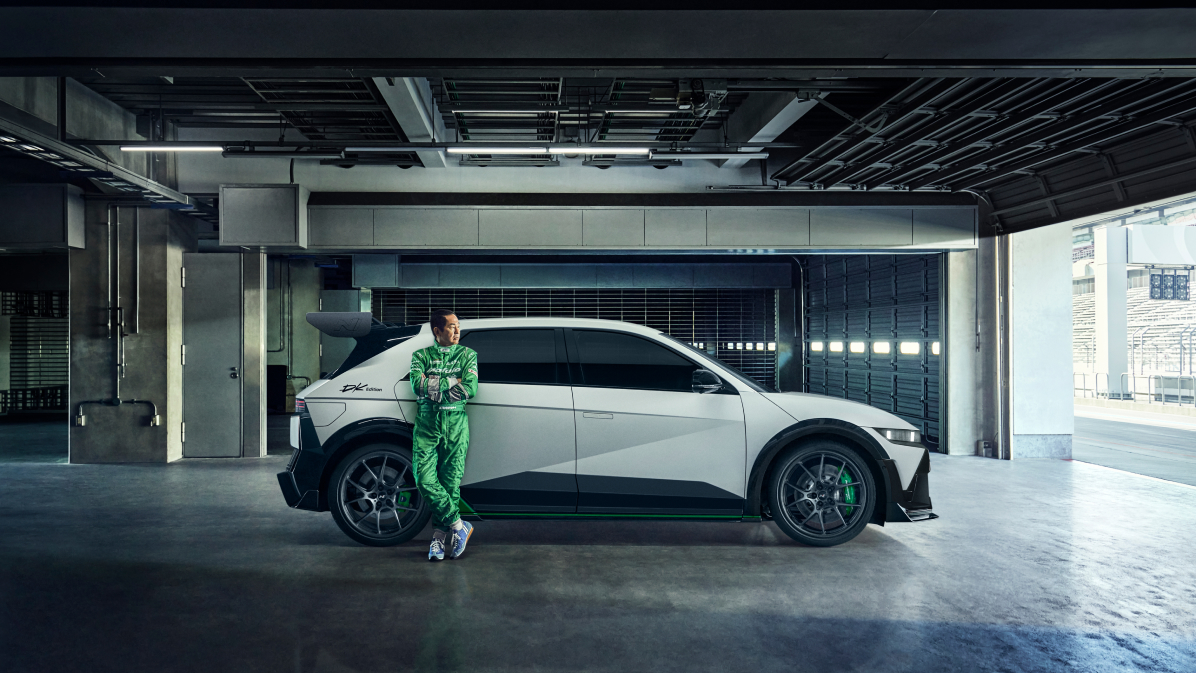 A person is leaning against the right rear door of the IONIQ 5 N DK Edition vehicle.